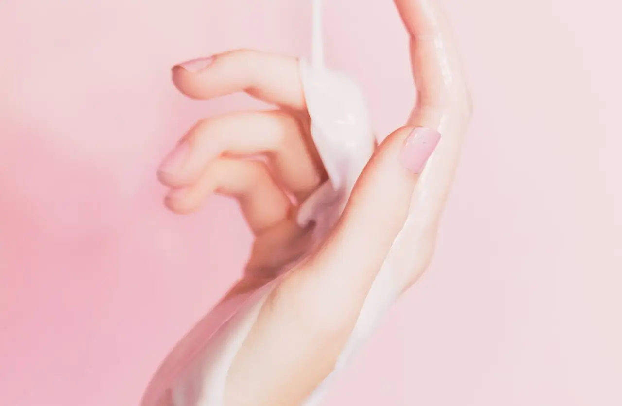 a woman's hand holding a bottle of lotion